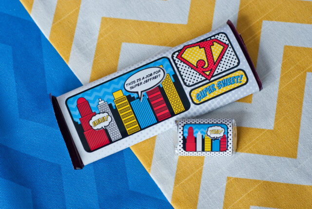 Vintage comic book birthday party setup with colorful superhero desserts and printable decor