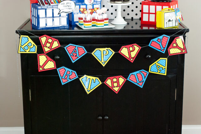Vintage comic book birthday party setup with colorful superhero desserts and printable decor