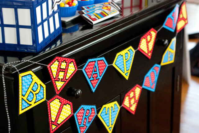 Vintage comic book birthday party setup with colorful superhero desserts and printable decor