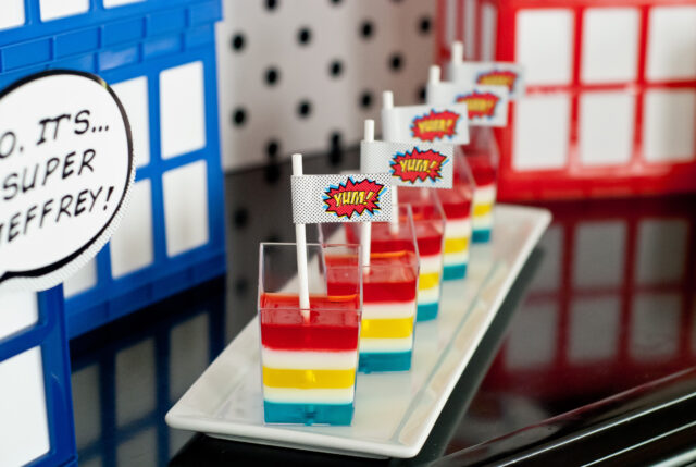 Vintage comic book birthday party setup with colorful superhero desserts and printable decor