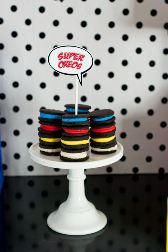 Vintage comic book birthday party setup with colorful superhero desserts and printable decor