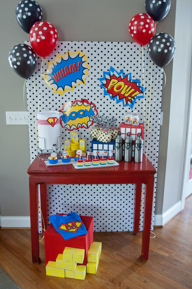 Vintage comic book birthday party setup with colorful superhero desserts and printable decor
