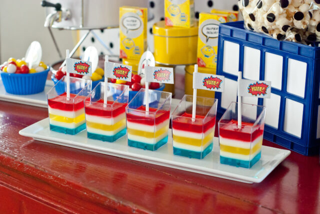 Vintage comic book birthday party setup with colorful superhero desserts and printable decor