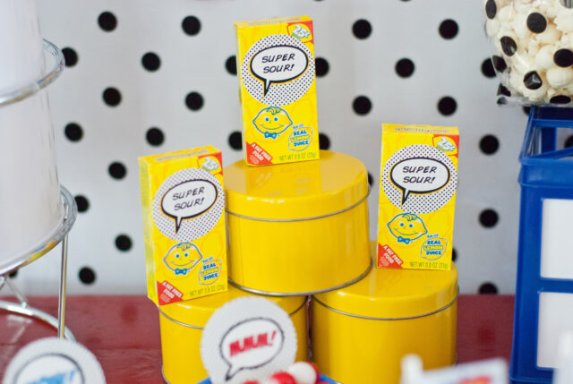 Vintage comic book birthday party setup with colorful superhero desserts and printable decor