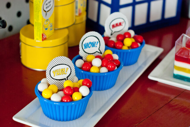 Vintage comic book birthday party setup with colorful superhero desserts and printable decor