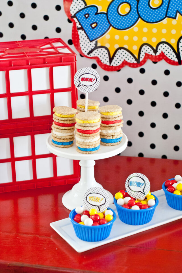 Vintage comic book birthday party setup with colorful superhero desserts and printable decor