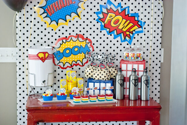 Vintage comic book birthday party setup with colorful superhero desserts and printable decor