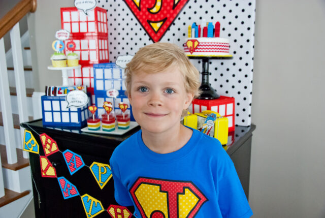 Vintage comic book birthday party setup with colorful superhero desserts and printable decor