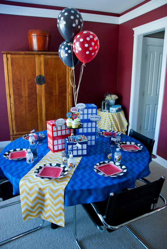 Vintage comic book birthday party setup with colorful superhero desserts and printable decor